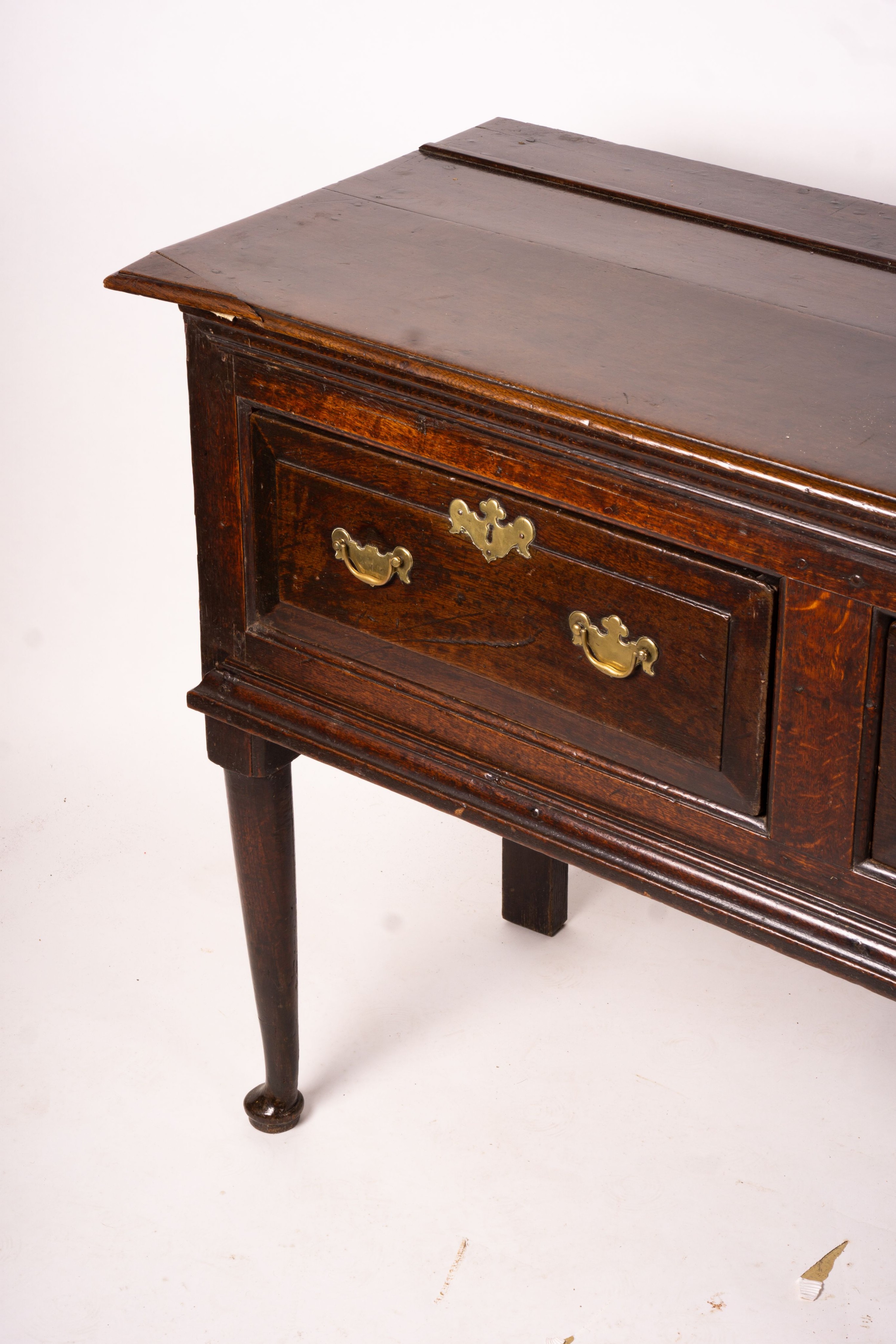 An 18th century oak low dresser on pole turned legs and pad feet, length 198cm, depth 53cm, height 88cm